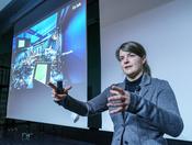 Monika Aidelsburger erläutert einen komplexen Versuchsaufbau im Labor...
